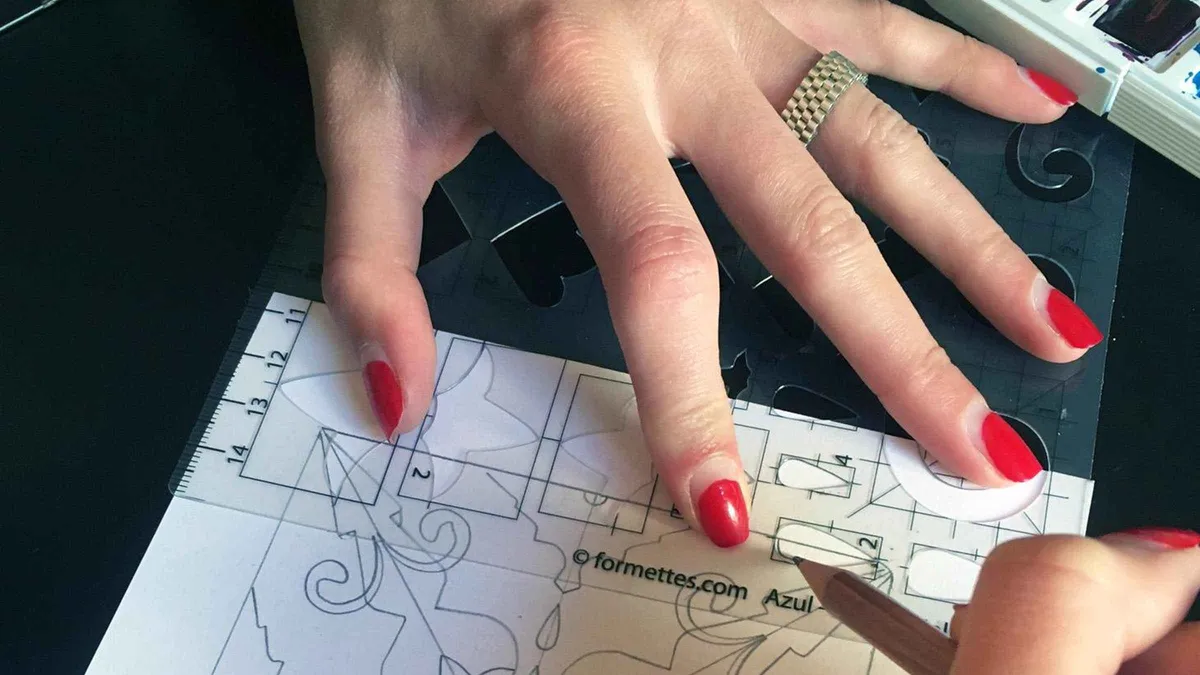 Hands painting a blue azulejo tile design in a Lisbon tile workshop, a hands-on alternative among museums in Lisbon