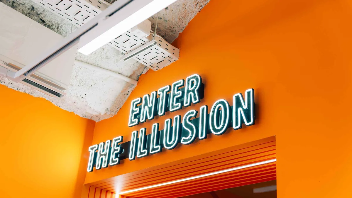 A visitor in an inverted optical illusion room at the Museum of Illusions on a Lisbon museum ticket, one of the museums in Lisbon